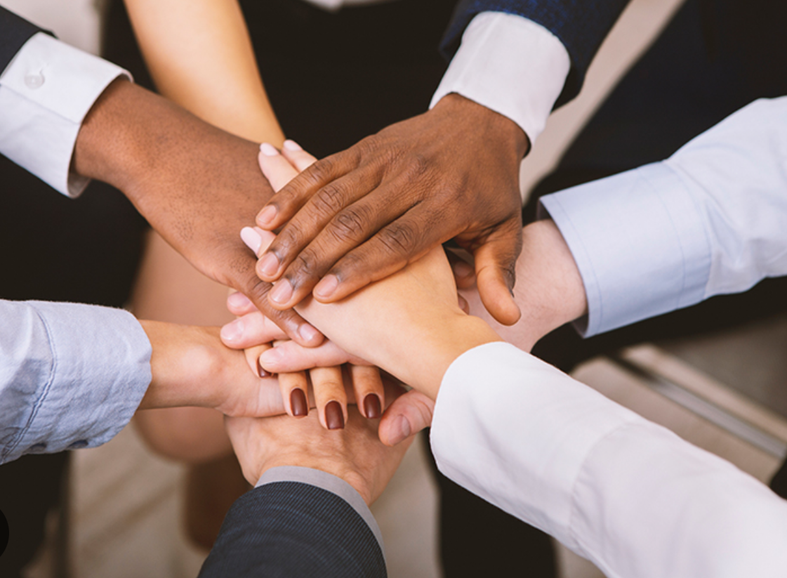 A group of people with their hands together.